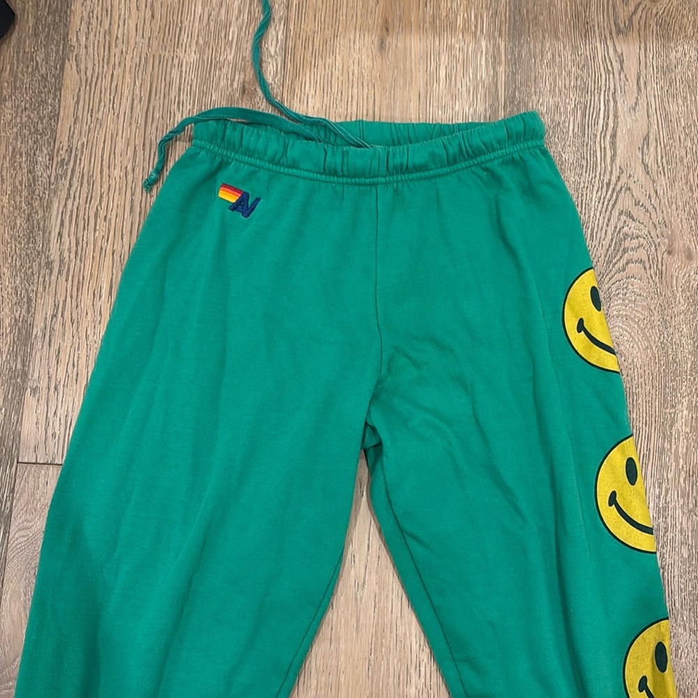 Green aviator nation, sweatpants size small with smiley faces down the leg